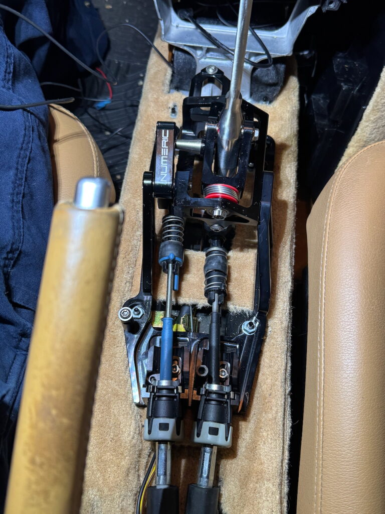 You should be able to send the RCA cable down under the shift assembly with the other wiring, through to the back of the dash console. You can see the RCA wire exiting at the upper left.