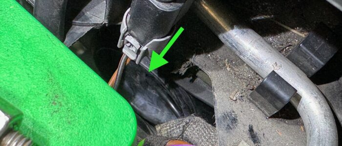 A bit fuzzy but arrow points at the grommet, and the cut in the grommet, the antenna cable passing through the grommet into the cabin.