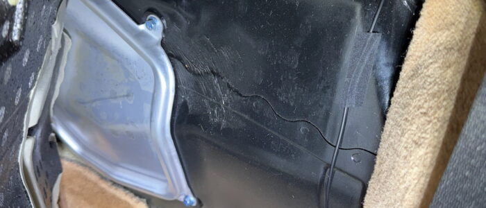 Behind driver's seat. Pull carpet back, tape RCA cable down, out of the way.